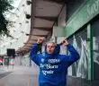 man in blue hoodie standing near green and white building during daytime